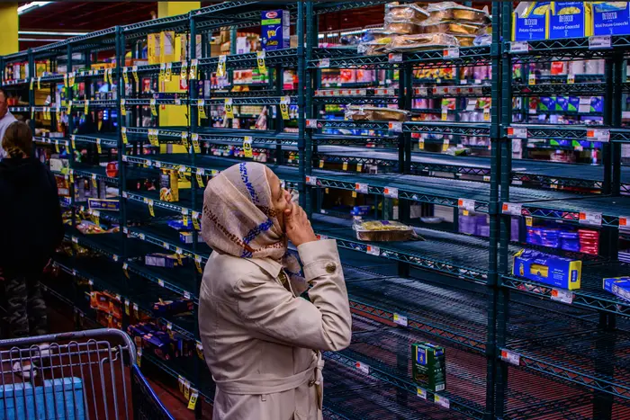 A photo of a woman at a mostly empty grocery store
